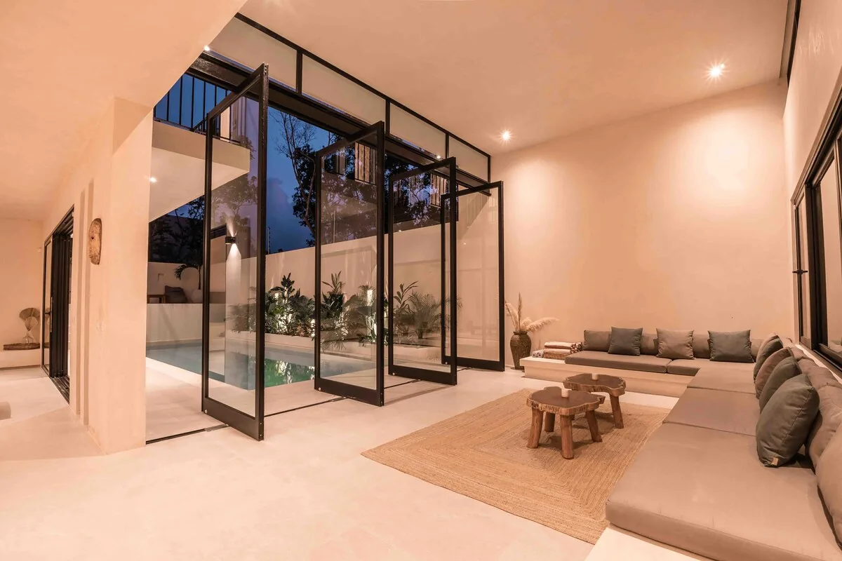 Sala minimalista Casa H con grandes ventanales y vista a la alberca